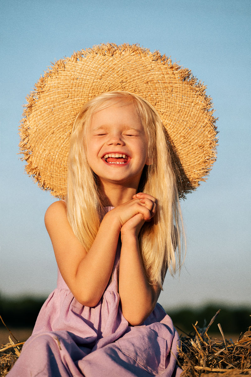 фотосессия детей на природе фото девочка летом в поле на закате в стогах сена в шляпе идеи